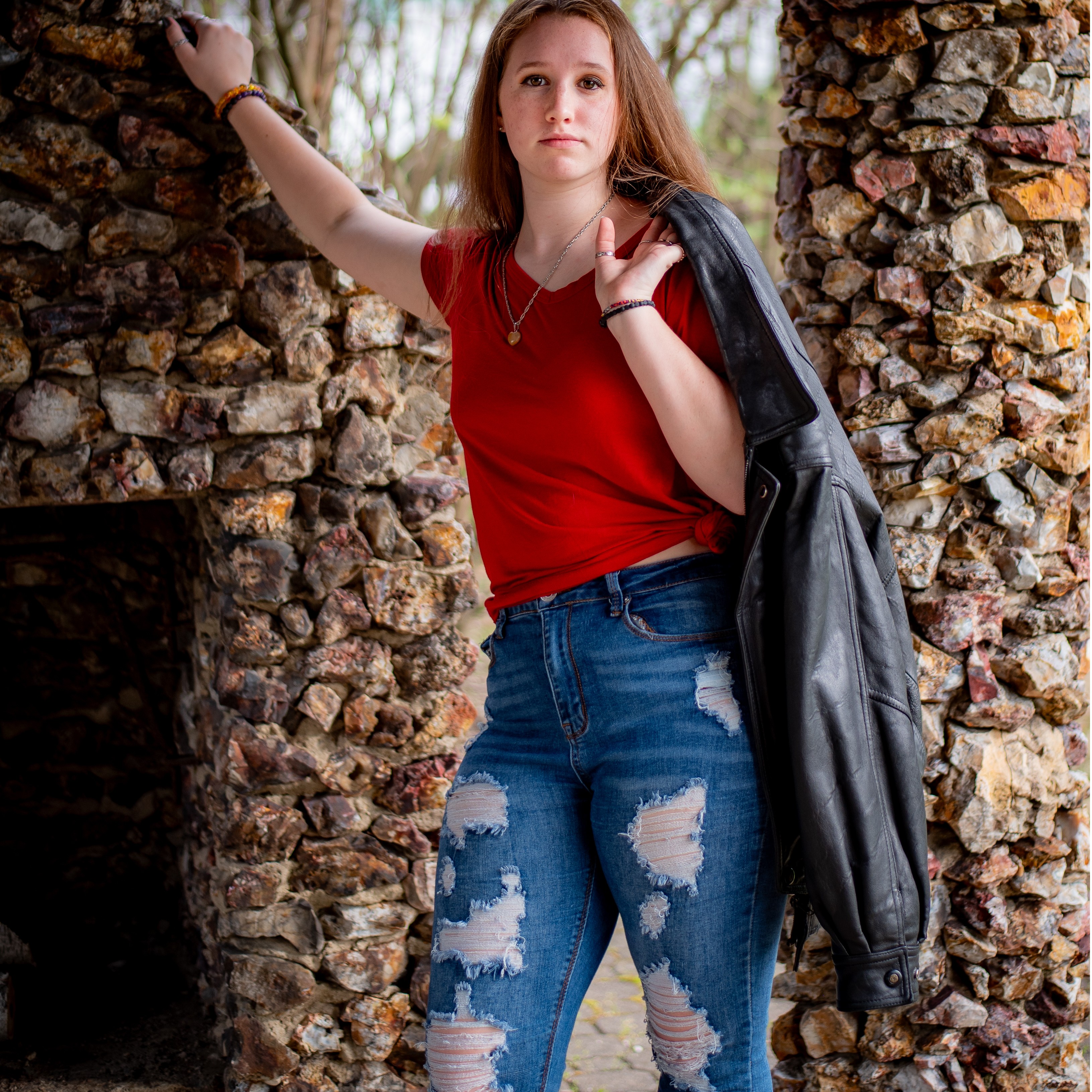 young woman leaning on outdoor stone fireplace
